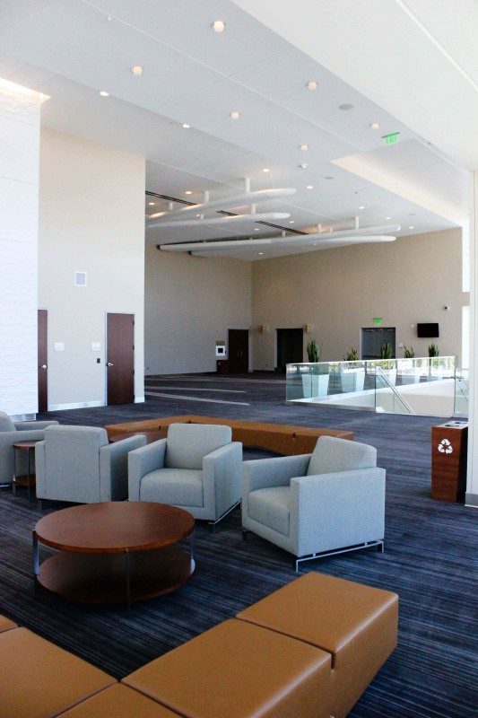 brown leather benches, low round tables, and gray armchairs arranged in a lobby.