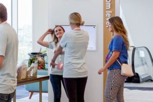 interacting around a digital display in a modern office lobby