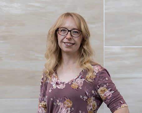 young woman in purple floral shirt
